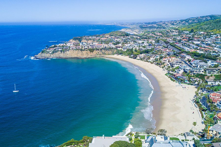 Contact - Aerial View of Emerald Bay, Laguna Beach, Southern California Displaying the Ocean With a Few Boats, the Beach, and City on a Sunny Day