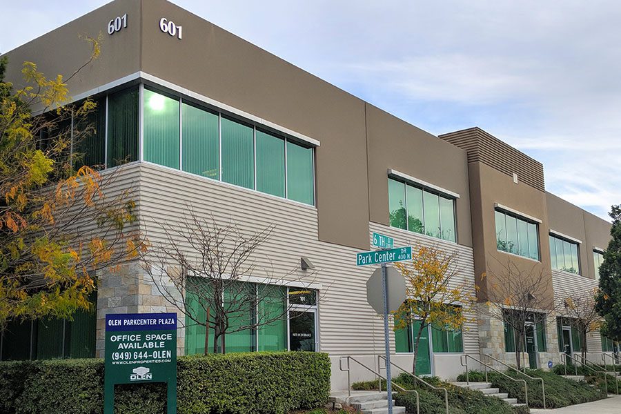 About Our Agency - Angled View of the Roberti's Insurance Agency, Inc. Office Displaying a Smooth and Brick Front With Trimmed Hedges During the Daytime